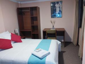 普诺Huaytusive Inn Hotel的酒店客房配有一张床、一张书桌和一张书桌。