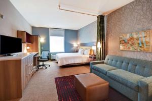 斯普林菲尔德Home2 Suites by Hilton Springfield North的酒店客房配有床、沙发和电视。