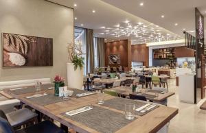 迪拜DoubleTree by Hilton Dubai Al Jadaf的餐厅内带桌椅的用餐室