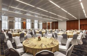 迪拜DoubleTree by Hilton Dubai Al Jadaf的一间大房间,房间内设有桌椅
