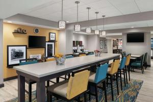 尚佩恩Hampton Inn Champaign Southwest的大型用餐室配有大桌子和椅子