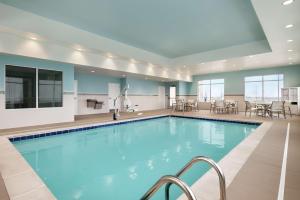 尚佩恩Hampton Inn Champaign Southwest的一座配有桌椅的酒店游泳池