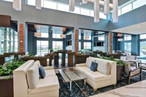 普兰菲尔德Embassy Suites By Hilton Plainfield Indianapolis Airport的大堂配有沙发和桌椅