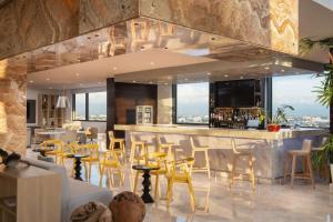 圣多明各Homewood Suites By Hilton Santo Domingo的餐厅设有配备黄色椅子的酒吧