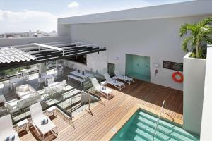 圣多明各Homewood Suites By Hilton Santo Domingo的一个带游泳池和椅子的房间和一个建筑
