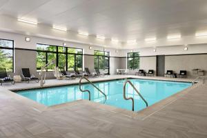 霍舍姆Homewood Suites By Hilton Horsham Willow Grove的游泳池位于酒店客房内,配有桌椅