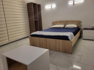 卡瓦达尔奇Jordanovi Premium Apartment的卧室配有1张床和1张白色桌子