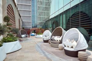 科威特Hilton Garden Inn Kuwait的坐在建筑物旁边的一排白色椅子