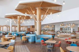拉斯阿尔卡麦Hampton by Hilton Marjan Island的餐厅的 ⁇ 染,配有桌椅