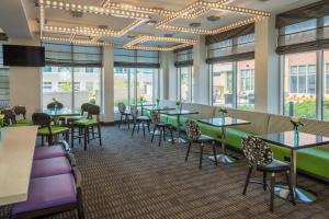 孟菲斯Hilton Garden Inn Memphis East/Germantown, Tn的用餐室设有桌椅和窗户。