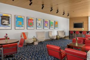 丹佛The Art Hotel Denver, Curio Collection by Hilton的一间设有桌椅和平面电视的等候室