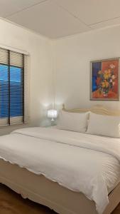 达叻府Rynn Hotel的白色卧室内的一张大白色床,设有窗户