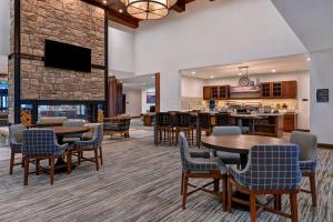 EagleHomewood Suites By Hilton Eagle Boise, Id的大堂设有桌椅和壁炉。