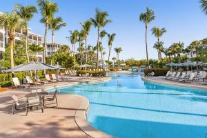 基韦斯特Hyatt Vacation Club at Beach House的度假村的游泳池,配有椅子和棕榈树