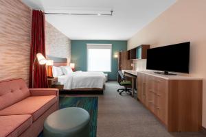 波卡特洛Home2 Suites By Hilton Pocatello, Id的配有一张床和一台平面电视的酒店客房