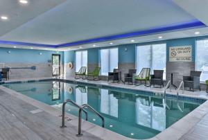 基恩Hampton Inn & Suites Keene的一座配有桌椅的酒店游泳池