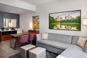 亚特兰大Embassy Suites By Hilton Atlanta Airport North的带沙发和书桌的客厅