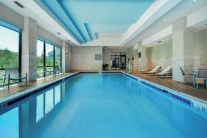 阿尔法利塔Embassy Suites By Hilton Alpharetta Halcyon的大楼内的一个蓝色海水游泳池