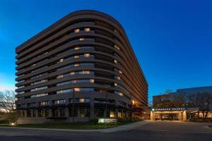 贝塞斯达Embassy Suites by Hilton Bethesda Washington DC的一座大型办公楼,窗户在黄昏时分开放