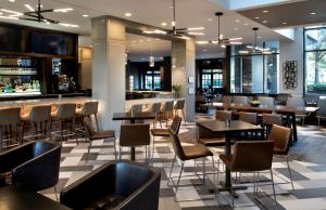 贝塞斯达Embassy Suites by Hilton Bethesda Washington DC的一间带桌椅的餐厅和一间酒吧