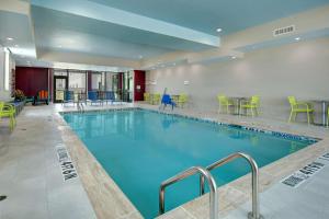 伯利森Home2 Suites By Hilton Burleson的一座配有桌椅的酒店游泳池