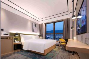 长沙长沙岳麓希尔顿花园酒店的配有一张床、一张书桌和一扇窗户的酒店客房