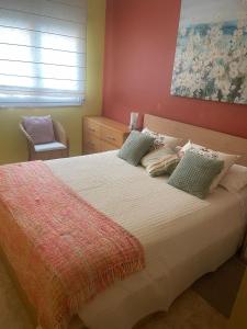 库尼特Cunit Beach的一间卧室配有一张带绿色枕头的大床