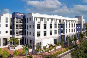 德尔雷比奇Hampton Inn Delray Beach的白色建筑的图象,上面有标志