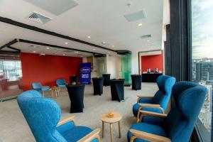 基多Hampton By Hilton Quito La Carolina Park的一间设有蓝色椅子和桌子的等候室