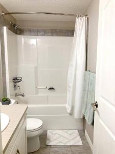 卡尔加里Mahogany Escape - Your Calgary Oasis的白色的浴室设有浴缸、卫生间和水槽。