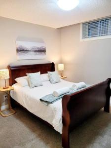 卡尔加里Mahogany Escape - Your Calgary Oasis的卧室配有一张带白色床单和枕头的大床。