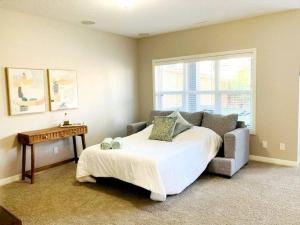 卡尔加里Mahogany Escape - Your Calgary Oasis的一间卧室配有一张床、一张桌子和一张沙发
