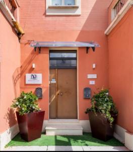 雷焦卡拉布里亚B&B De Nava Suite的一座建筑,前面有门和两棵植物
