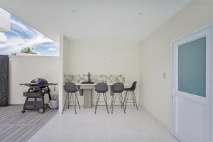 拉罗汤加Villa Varia的白色的房间,配有桌子和凳子