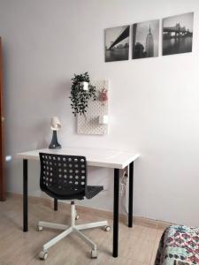阿格特Agaete Fray的一张带黑椅子的白色书桌和墙上的照片