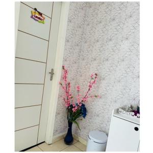 贝伦Hostel das Flores的浴室内装有粉红色花卉的花瓶