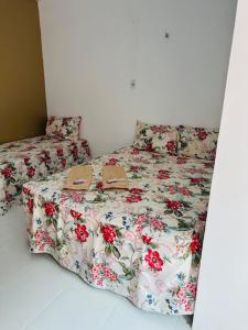 贝伦Hostel das Flores的一张带花卉被子的床,上面有两双鞋