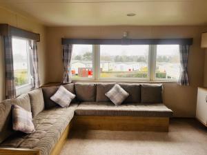 罗切斯特Kent Coast 3 bedroom holiday home的客厅设有一张沙发,配有大窗户