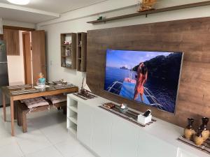 伊波茹卡Flat Confort Pé na Areia的客厅设有壁挂式平面电视。
