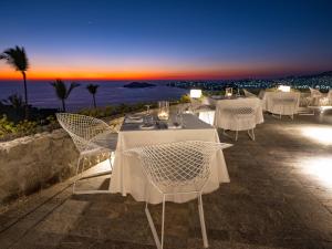 阿卡普尔科拉斯萨斯阿卡普尔科酒店的一间设有白色桌椅的海洋餐厅