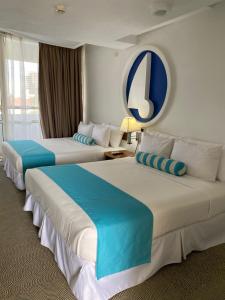 PampatarAquarius Hotel Boutique的酒店客房,配有两张蓝色和白色的床