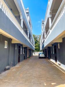 基利菲KITRA Cozy Homes的两栋建筑之间的街道上停泊的汽车