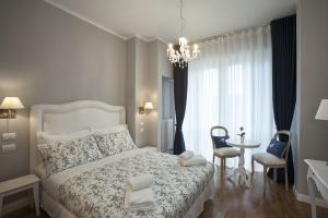 佛罗伦萨纳尼娜住宿加早餐旅馆的卧室配有白色的床和桌椅