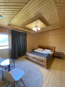 亚布卢尼齐亚Villa Filiak的木制客房内的一间卧室,配有一张床