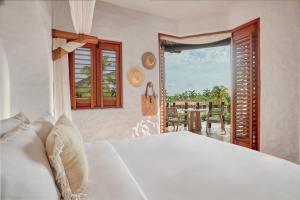 锡瓦塔塔内霍La Villa Luz (sólo adultos)的一间卧室配有一张床,享有庭院的景色