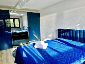 ForstinningWie Zuhause! Wohnung mit Garten的一间卧室配有蓝色的床和镜子