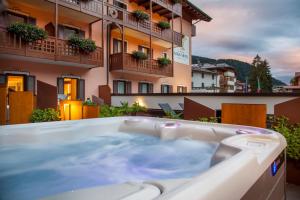 安达洛Adler Hotel Wellness & Spa - Andalo的热水浴池位于酒店阳台上