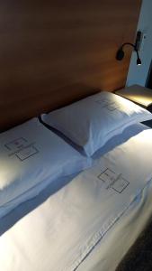 圣博尔雅661 Hospedagem的房间里的床上有两个白色枕头