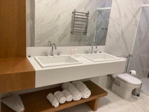 格拉玛多Austin Suites Gramado的白色的浴室设有水槽和卫生间。