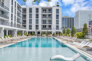 迈阿密Exclusive Condo in Downtown Miami With Pool Views and Free Parking的一座带椅子的游泳池以及一座建筑
